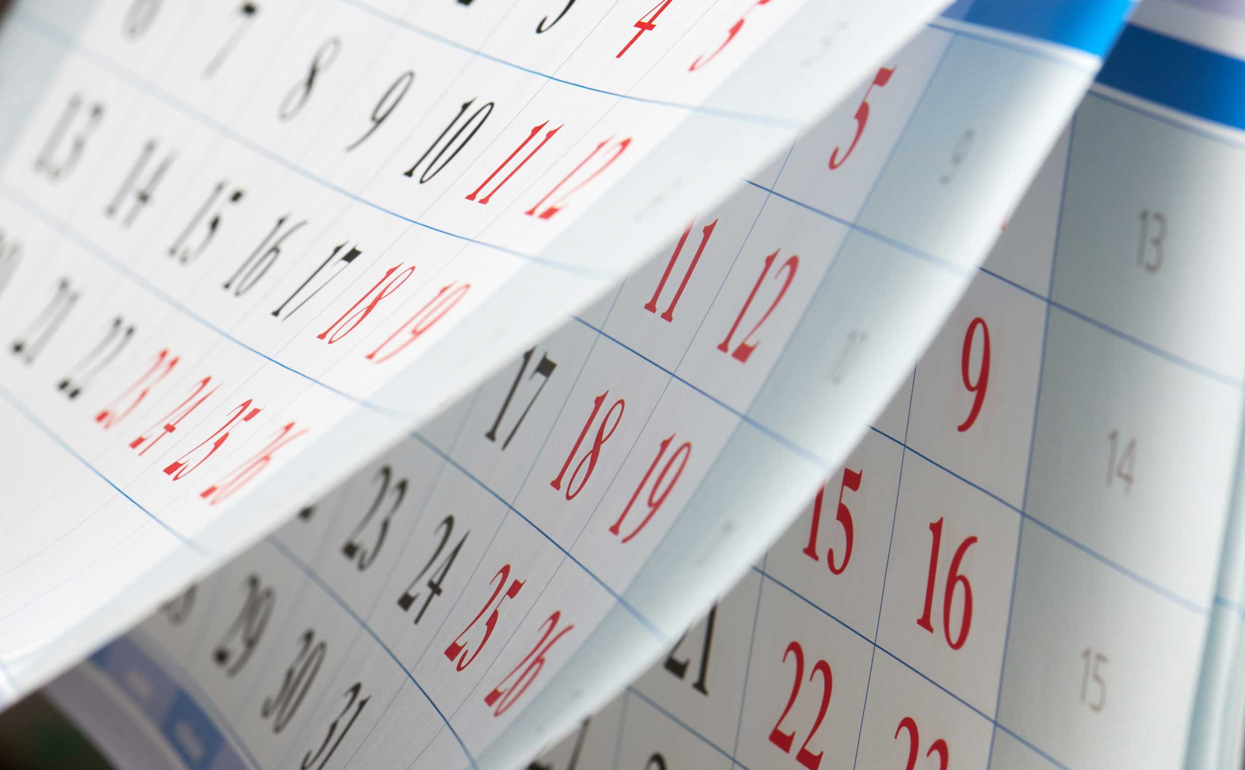 Unseen hands leafing through a calendar.