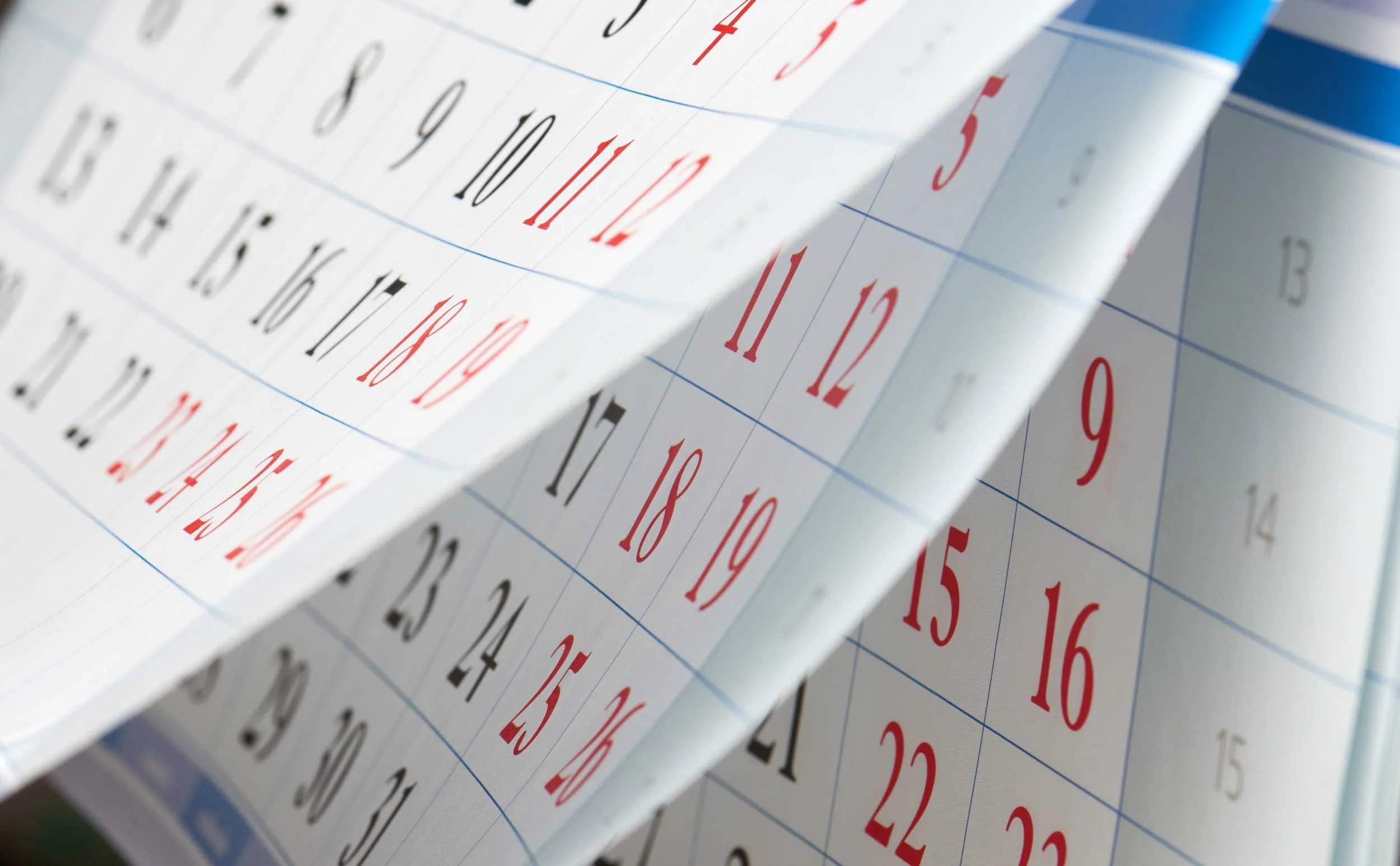 Unseen hands leafing through a calendar.